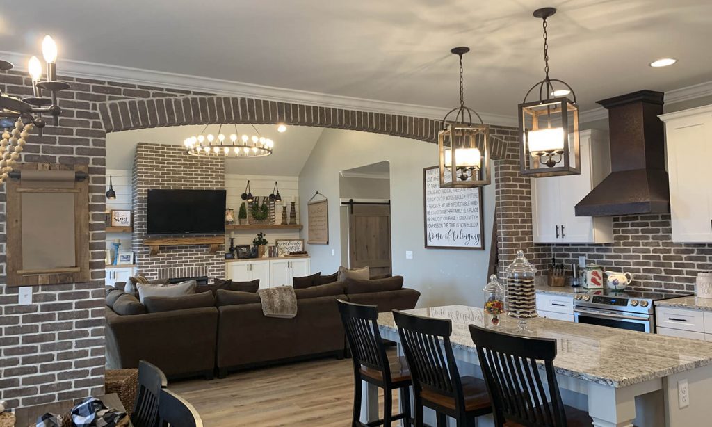 Interior home showing kitchen and living room with brick accents 