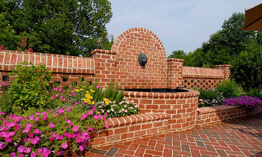 outdoor brick pathway with pink and yellow flowers in spring