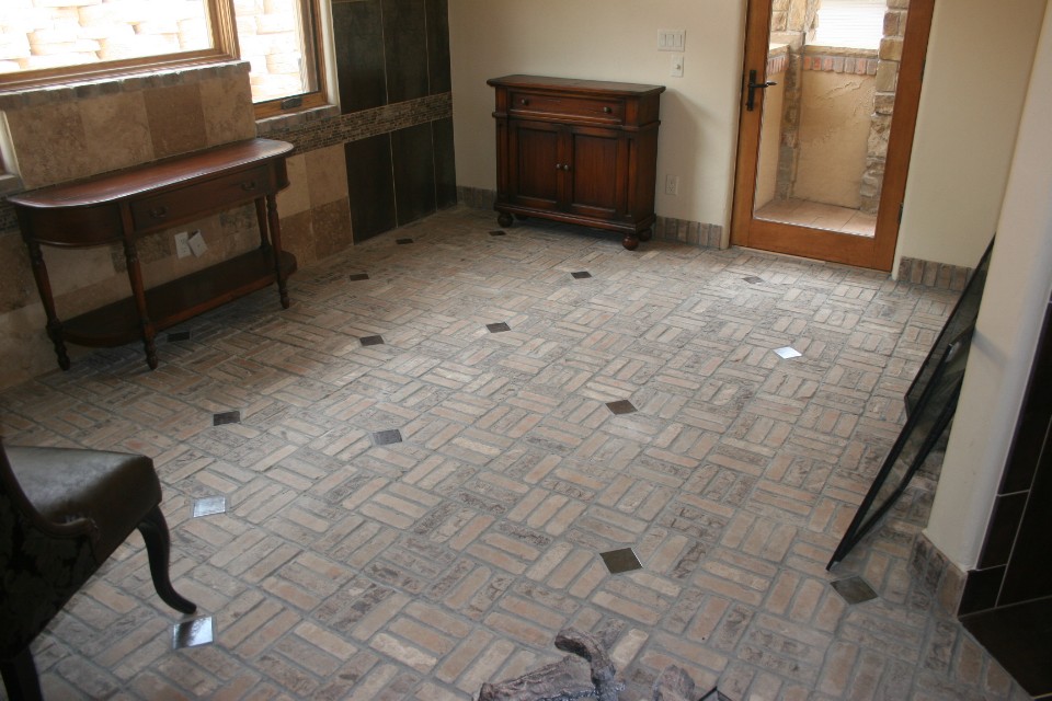Close up view of a custom-built parquet brick floor featuring geometric squares paired with decorative tile inlays.