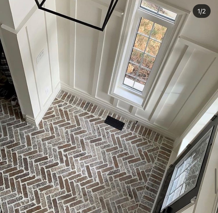 Elegant herringbone brick entryway featuring a classic zigzag pattern, creating a welcoming entrance.