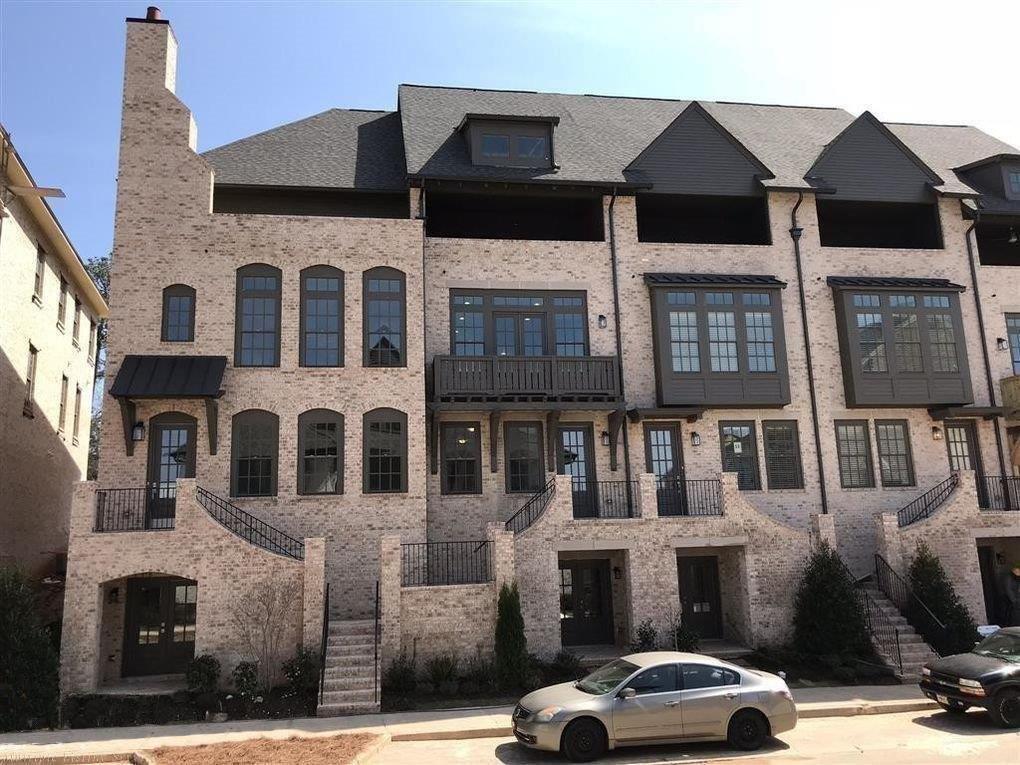 Row of Tudor-inspired townhomes in Logan Canyon brick from General Shale, with dark windows and trim.